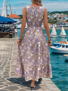 Rear view of women's sleeveless floral maxi dress with tiered skirt at a sunny harbor