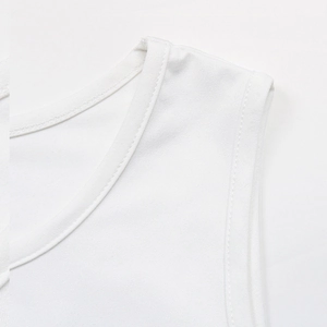 Close-up of white knitted tank top showing high-quality stitching on shoulder and neckline