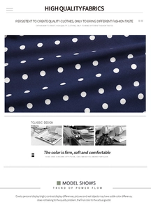 Detail view of high quality navy blue fabric with classic white polka dot pattern and texture
