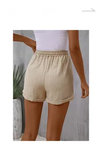 Detail of light beige high-waisted shorts featuring elastic waistband and vertical texture