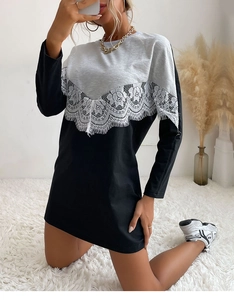 Detail of color-block dress showing white lace patchwork between grey and black fabric