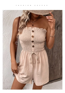 Detail of smocked bodice and decorative buttons on beige strapless summer romper
