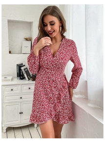 Detail of red floral wrap dress featuring a V-neckline and elegant ruffle hemline