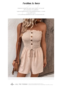 Detail of smocked strapless romper with decorative brown buttons and waist tie