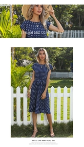 Detail of navy blue polka dot dress featuring short sleeves and a waist belt for women