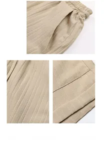 Detail view of beige pleated shorts featuring elastic waist and high-quality texture