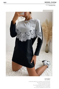 Detail of delicate white V-shaped lace splicing on a grey and black sweater dress
