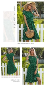 Detail view of green polka dot dress with waist tie and pleated skirt in outdoor setting