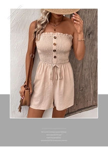 Detailed close-up of beige strapless romper with ruffled texture and button decoration