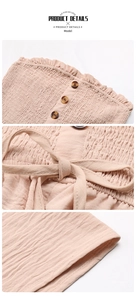Detail view of pink smocked fabric with tortoiseshell buttons and waist tie design