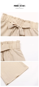Dettaglio della vita elastica arricciata e del fiocco sui pantaloni beige operati