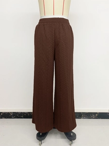 Close-up of wide elastic waistband and high-waisted texture on brown wide-leg pants