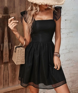 Detail of black mini dress featuring square neck and plaid mesh texture fabric