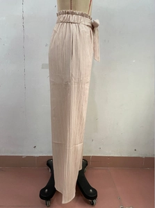 Dettaglio dei pantaloni a gamba larga plissé con vita alta elastica e coulisse regolabile
