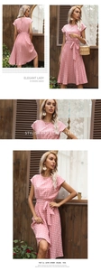 Close-up detail of pink polka dot dress showing waist tie and pleated elegant summer fabric