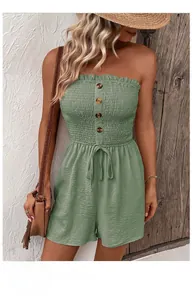 Detail of sage green smocked tube romper featuring wooden buttons and waist tie