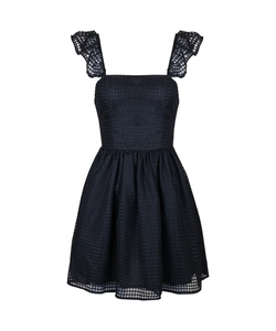 Detailed macro view of black sleeveless dress showing ruffled lace straps and checkered fabric