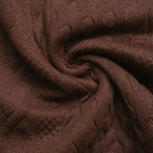 Macro shot of dark brown knit fabric with a diamond texture and soft drape detail