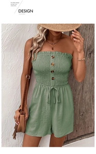 Detail of sage green strapless romper featuring smocked chest and decorative wooden buttons