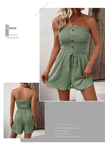 Detail of smocked strapless sage green romper with drawstring waist and wooden buttons