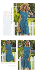 Detail of teal polka dot midi dress with pleated skirt and waist tie in outdoor setting