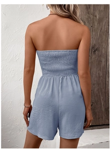 Detail view of sky blue smocked strapless romper with textured fabric from back angle