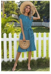 Peacock blue polka dot dress detail with pleated skirt and woven straw hat accessory