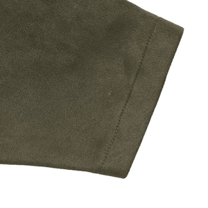 Gros plan détaillé sur la texture du daim vert olive et les coutures de l'ourlet