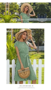 Detail of green polka dot pleated summer dress with waist tie in a garden setting