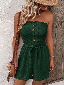Detail of smocked strapless dark green jumpsuit featuring front buttons and drawstring waist