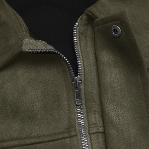 Détail d'une veste vert armée en faux daim avec fermeture éclair argentée et bouton pression