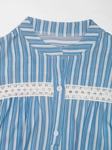 Detail of the blue striped blouse featuring white lace cut-out and button collar