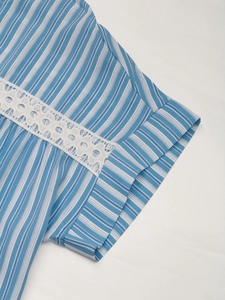 Close-up of blue and white striped shirt cuff with delicate white lace hollow detail