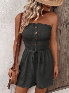 Detail of dark grey smocked tube top romper featuring retro buttons and tie-waist design