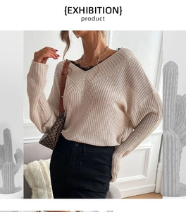 Detail of beige V-neck knitted sweater featuring elegant lace trim and thick ribbed texture