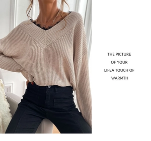 Detailed view of the V-neck knit sweater with elegant black lace trim and beige fabric