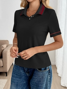 Close-up of black ribbed polo shirt with red contrast stripes on collar and sleeves