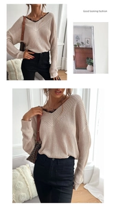 Detail of elegant V-neck knit sweater with delicate black lace trim on apricot fabric