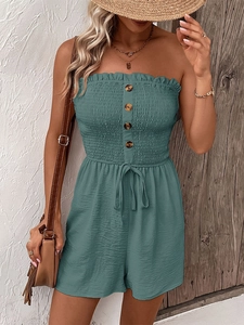 Close-up of smocked tube top jumpsuit with decorative buttons and drawstring waist detail