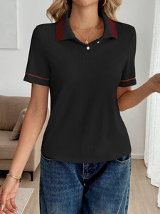 Detail of black knit polo shirt featuring red contrast stripes on collar and cuffs