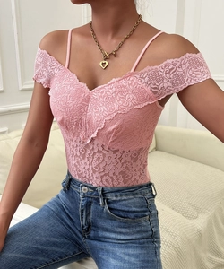Détail d'un body rose en dentelle florale avec épaules dénudées et décolleté en V chic