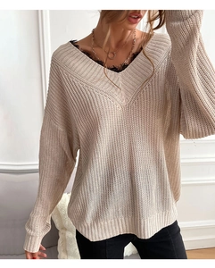 Detail of loose knit beige V-neck sweater with elegant black lace trim and drop shoulders
