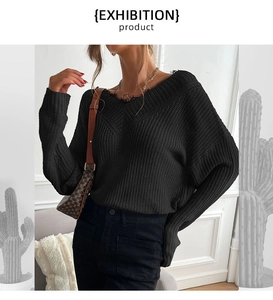 Detail of V-neck knit sweater showing delicate black lace trim and textured fabric