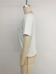 Dettaglio della t-shirt bianca a maniche corte in maglia a coste con tessuto strutturato