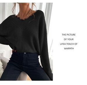 Close-up of black V-neck knit sweater featuring distressed raw edges and chunky texture