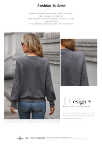Close-up of dark grey sweatshirt featuring 3D geometric texture and ribbed knit cuffs
