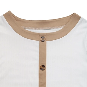 Dettaglio girocollo a contrasto e bottoni marroni sulla t-shirt bianca in maglia a coste