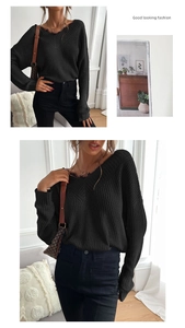 Close-up of black V-neck knit sweater featuring delicate lace trim and ribbed texture
