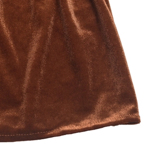 Détail de la texture du tissu en velours marron et de l'ourlet propre sur la manche