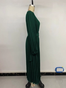 Detail of dark green pleated long dress with elegant waistband and lantern sleeves